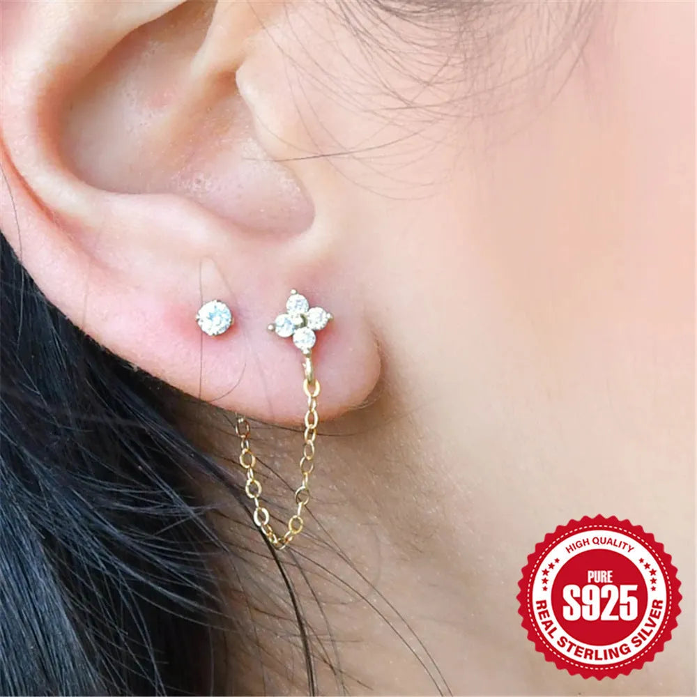 S925 sterling silver geometric drop earrings with flower, tassel, and chain details on an ear clip stud, in a golden tone.
