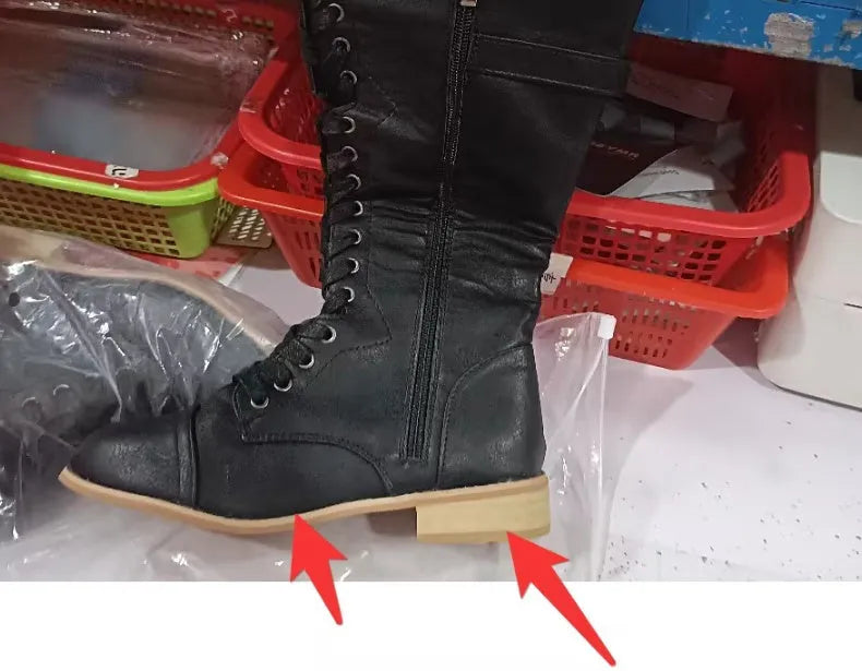 Women's black knight-style ankle boots with a cross-strap design across the front.