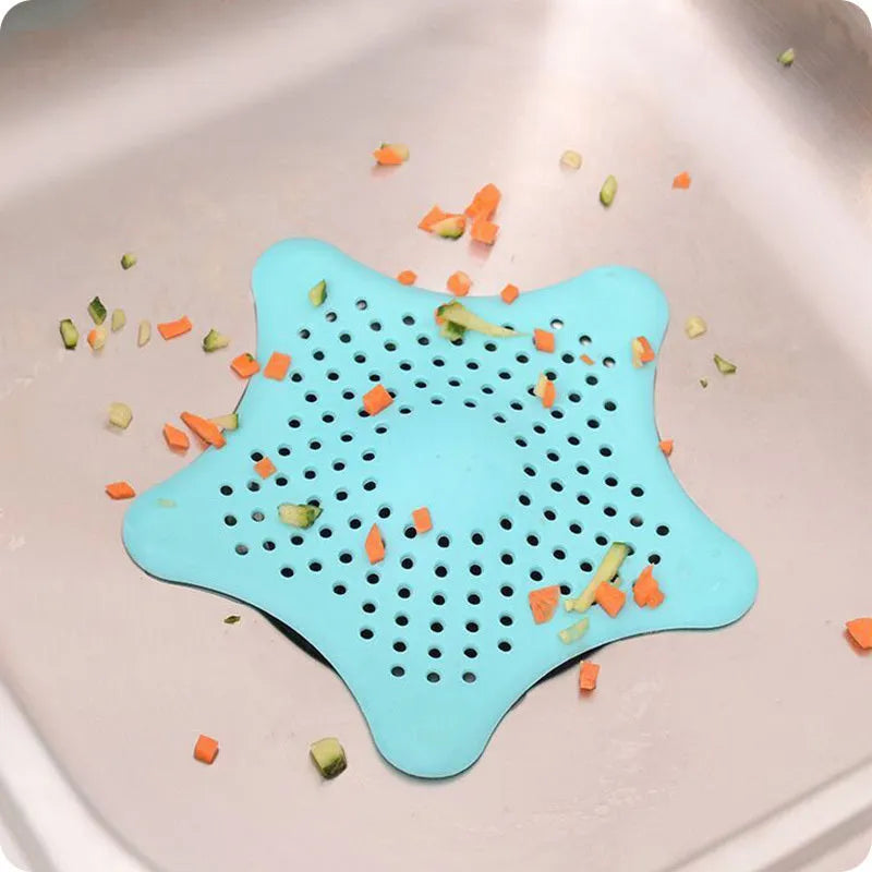 Three silicone starfish sink drain strainers in white, blue, and green with suction cups on bottom
