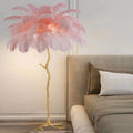 Tall decorative floor lamp with a cluster of white resin feathers next to a sofa.
