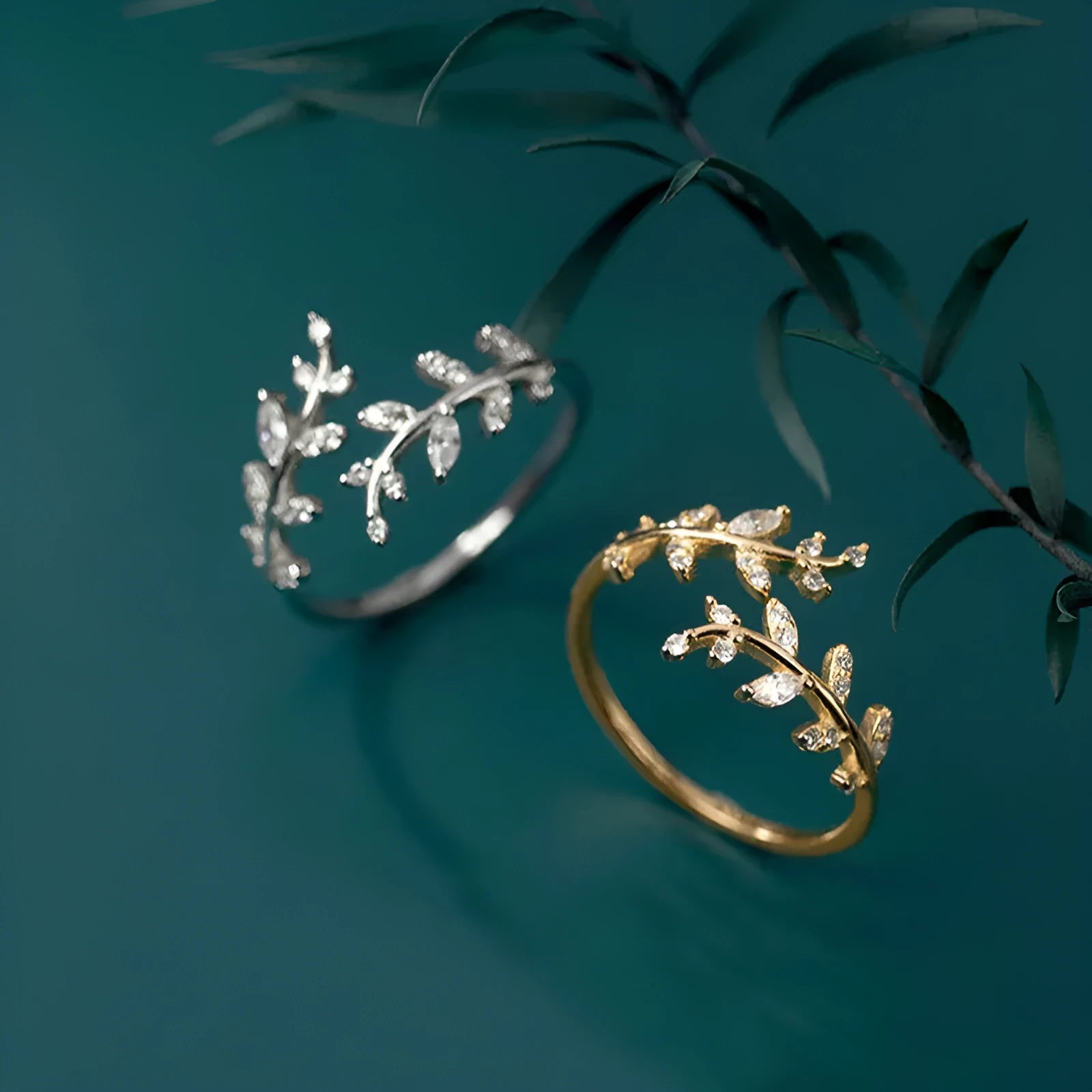 Gold and silver women's branch leaf fashion ring with geometric design on a plain background.
