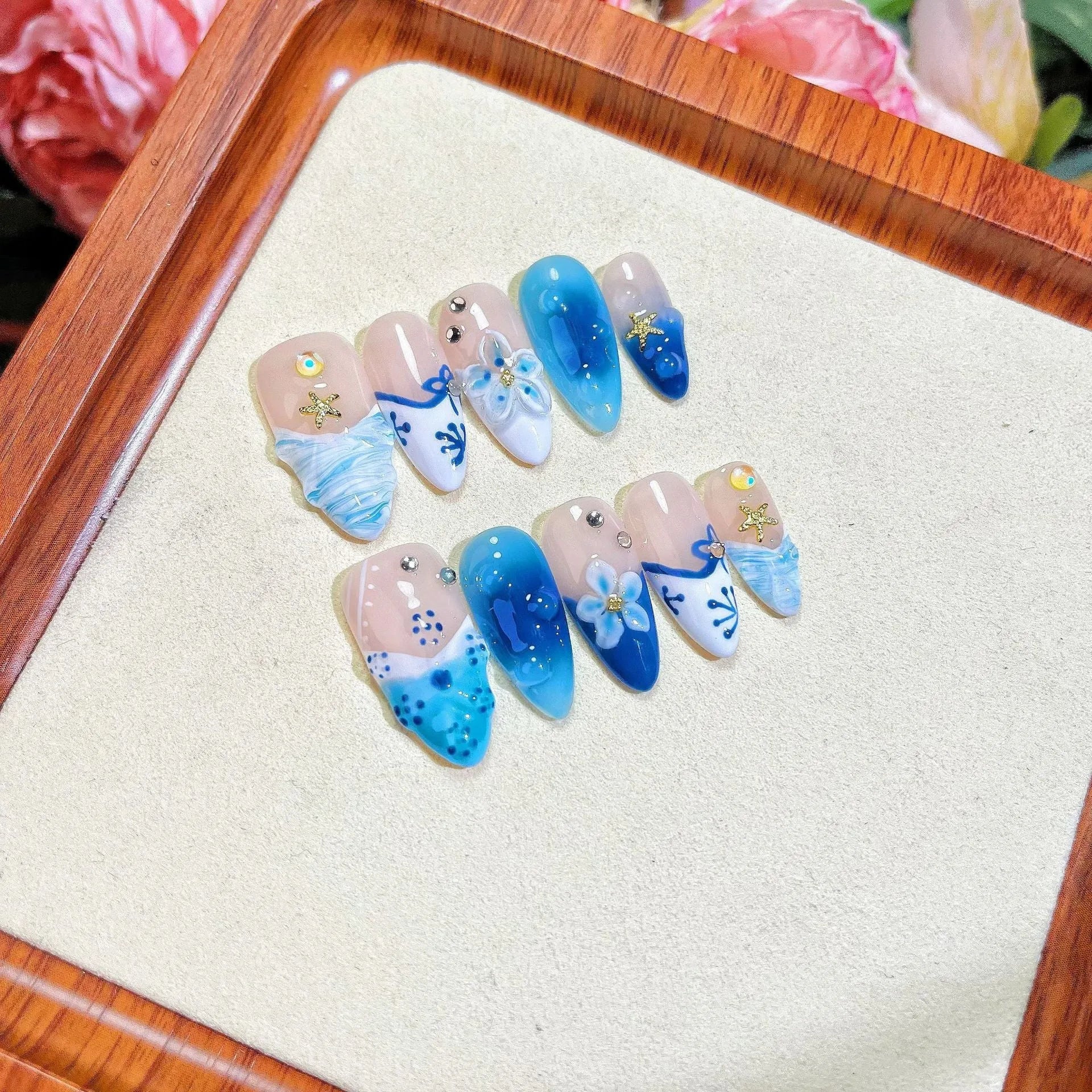 Blue hand-painted carved false nails in summer ice colour with transparent finish