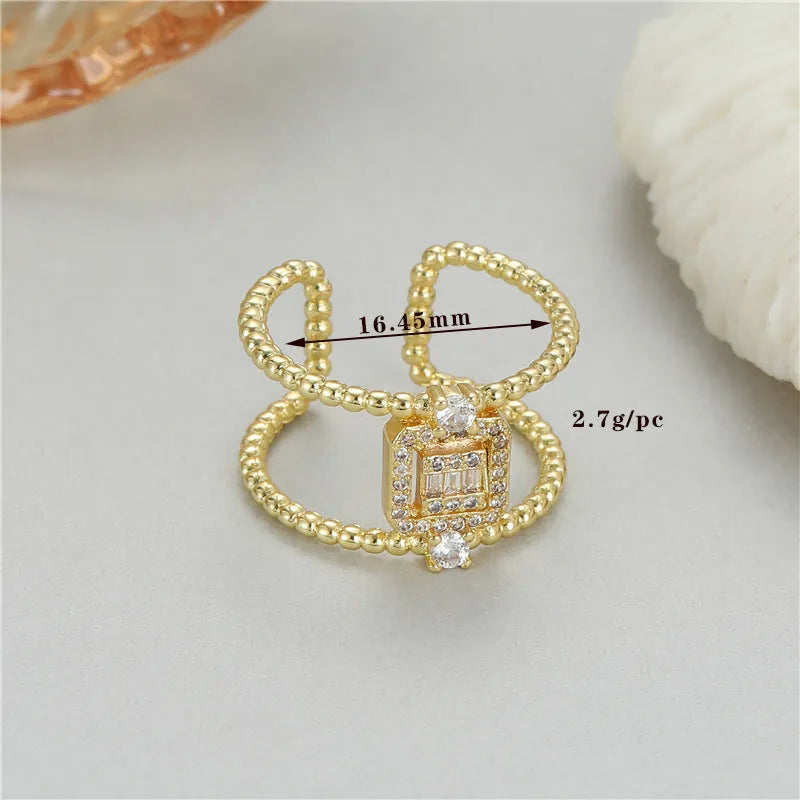 Copper open ring with 14K gold plating in an asymmetrical U-shape on a plain background.