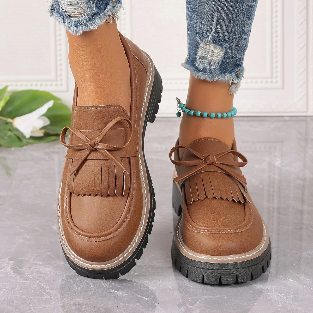 Women's black plus size slip-on loafers with tassel detail and a thick chunky heel.