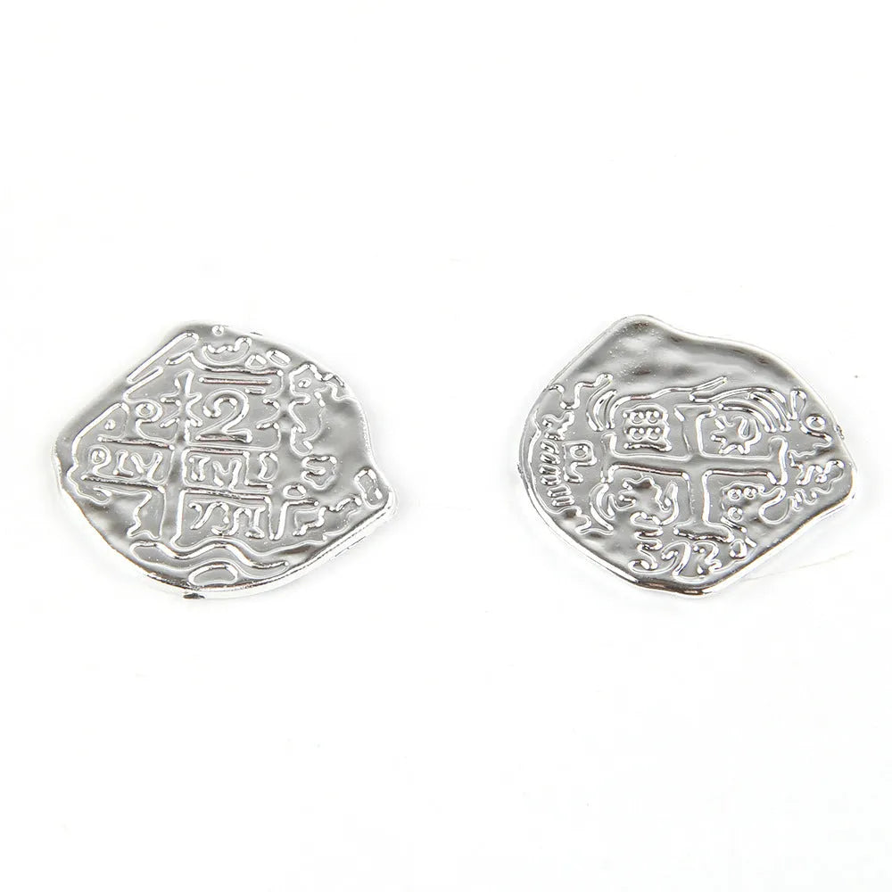 Set of 100 gold, silver and bronze coloured plastic replica Roman coins scattered on a surface.