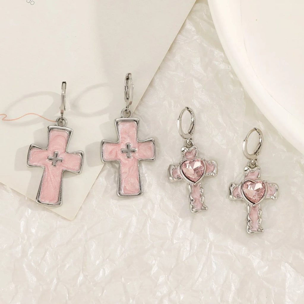 Women's alloy earrings showing cross, heart, and animal designs in white, black, and silver colour variations