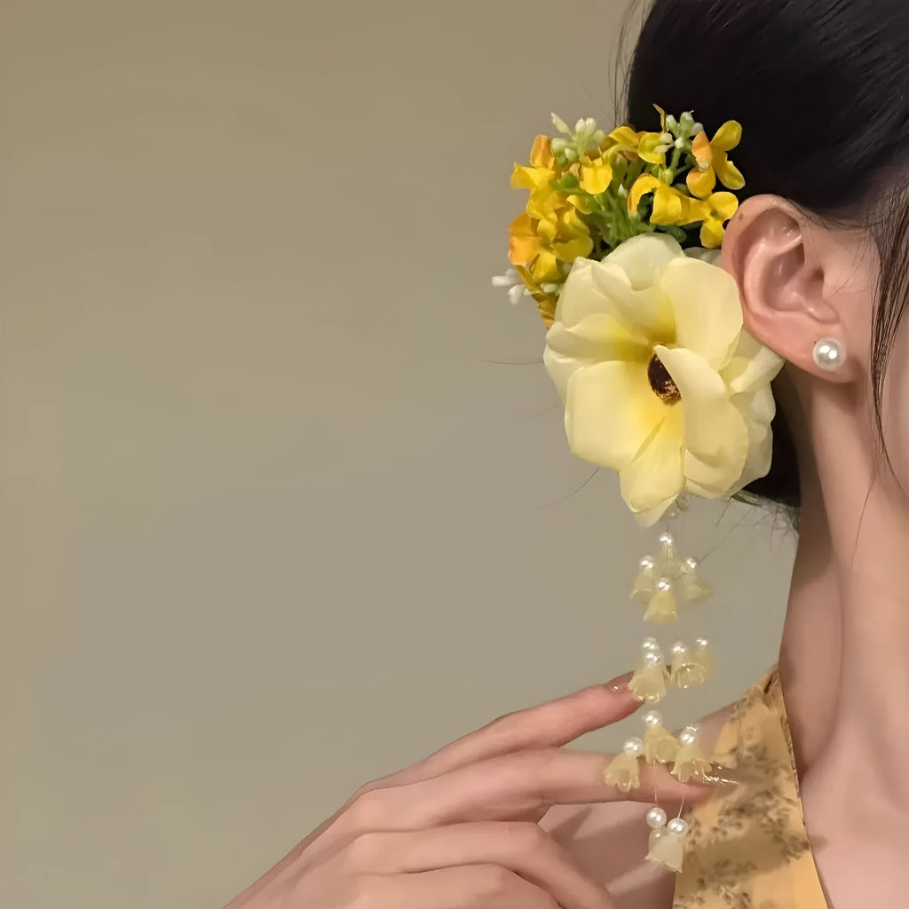 Floral tassel side clip hair accessory with pearl and linglan details on yellow background
