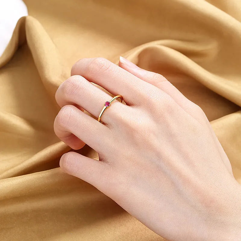 A simple copper geometric circle ring for women featuring a single diamond, shown on a hand.