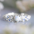 Close-up of a white electroplated alloy women's ring in a heart shape with floral and ocean detailing.
