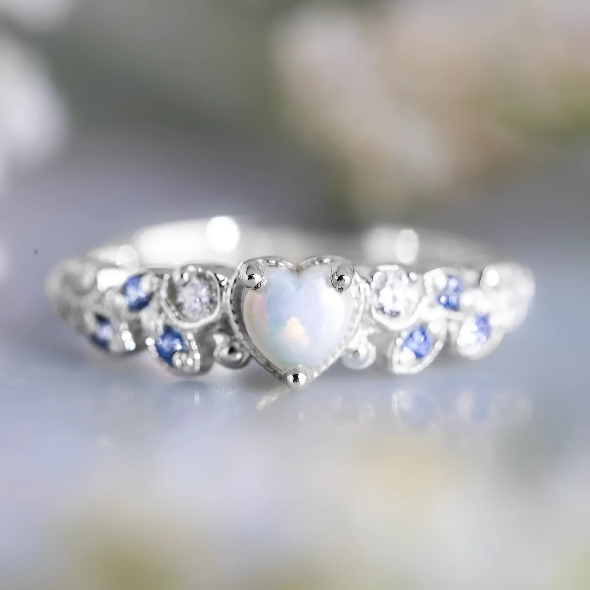 Close-up of a white electroplated alloy women's ring in a heart shape with floral and ocean detailing.