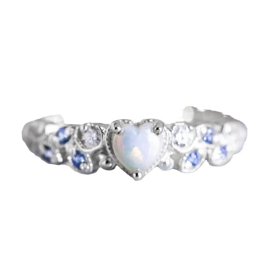 Close-up of a white electroplated alloy women's ring in a heart shape with floral and ocean detailing.