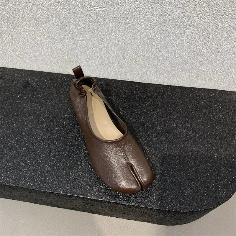 Women's black chunky heel pumps with a rounded toe and split toe horseshoe pea detail.