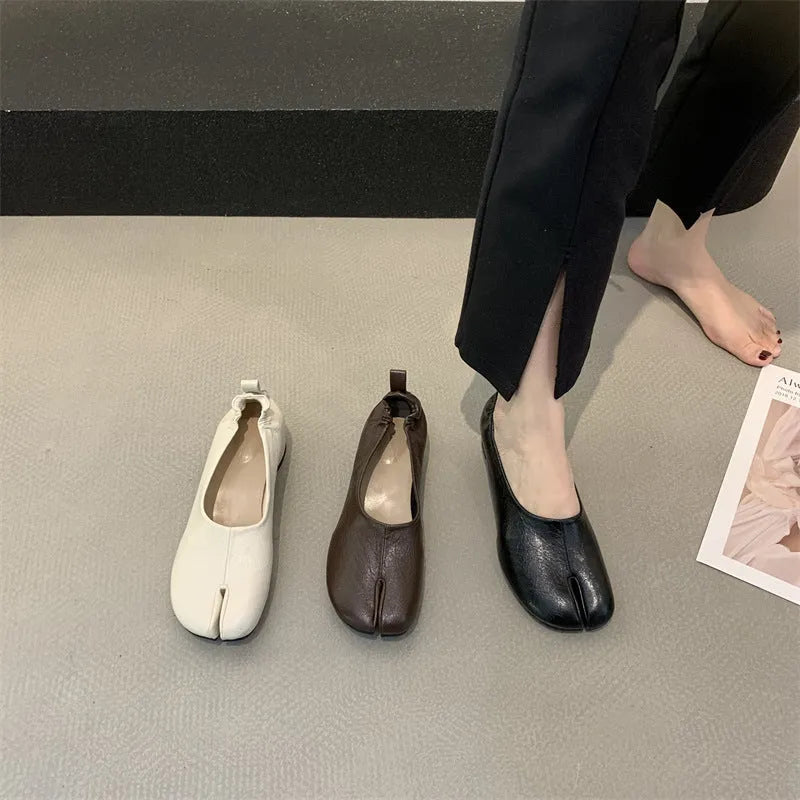 Women's black chunky heel pumps with a rounded toe and split toe horseshoe pea detail.