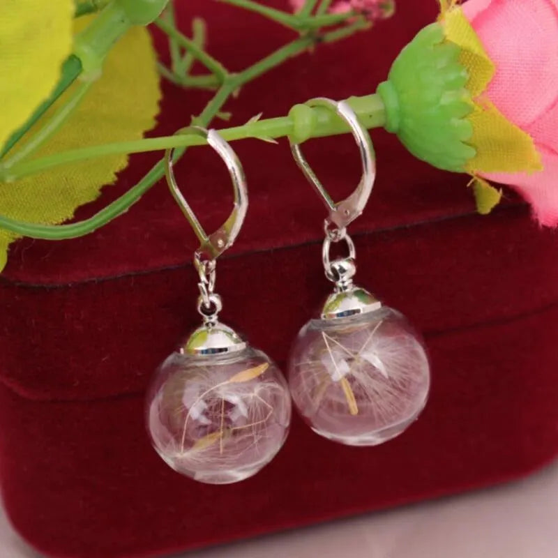 Transparent glass ball earrings with dandelion seed design on a silver French hook