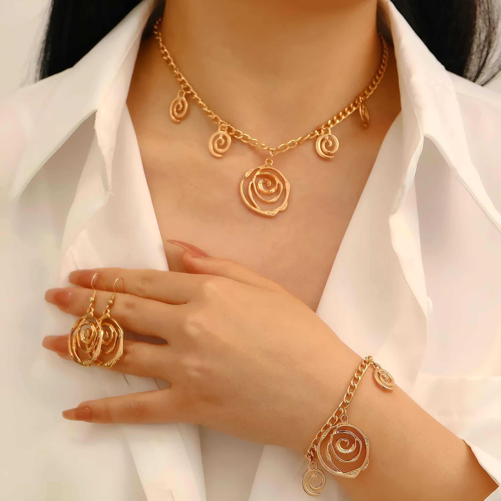 Gold and silver spiral donut pendant necklace, bracelet, and earrings set for women.