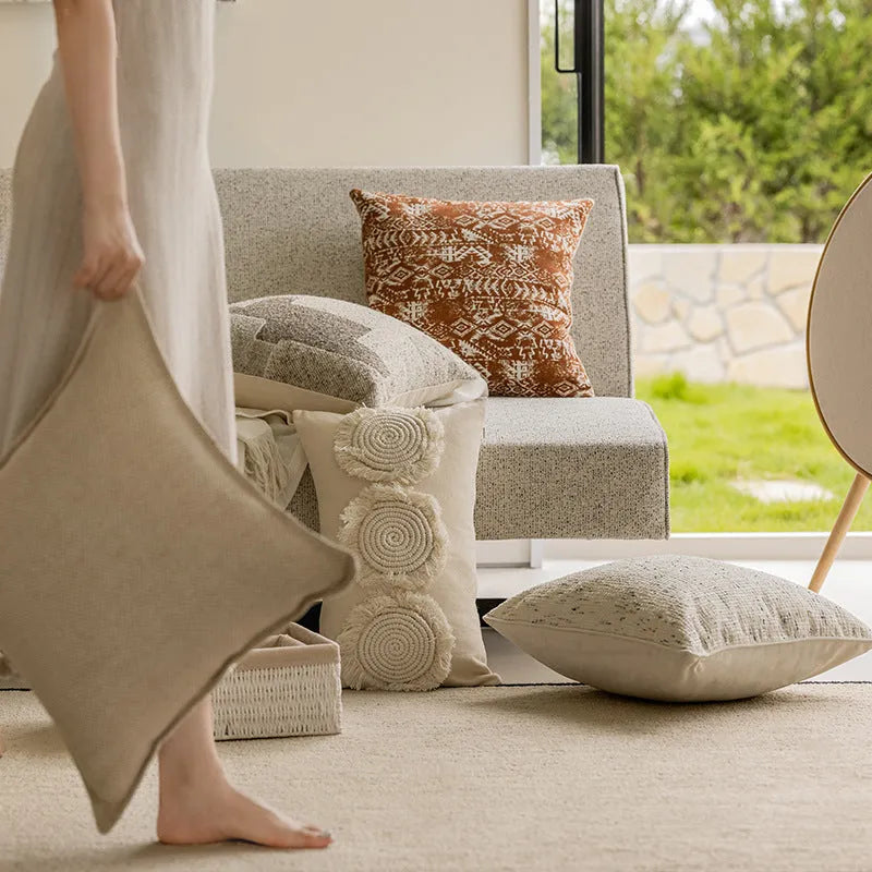 Solid colour decorative cushion on a sofa, showing its square shape and pp cotton filling.