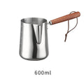 Stainless steel garland-spout milk jug with wooden handle showing measurement scale, for barista use.