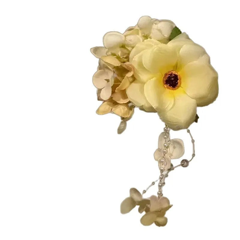Floral tassel side clip hair accessory with pearl and linglan details on yellow background