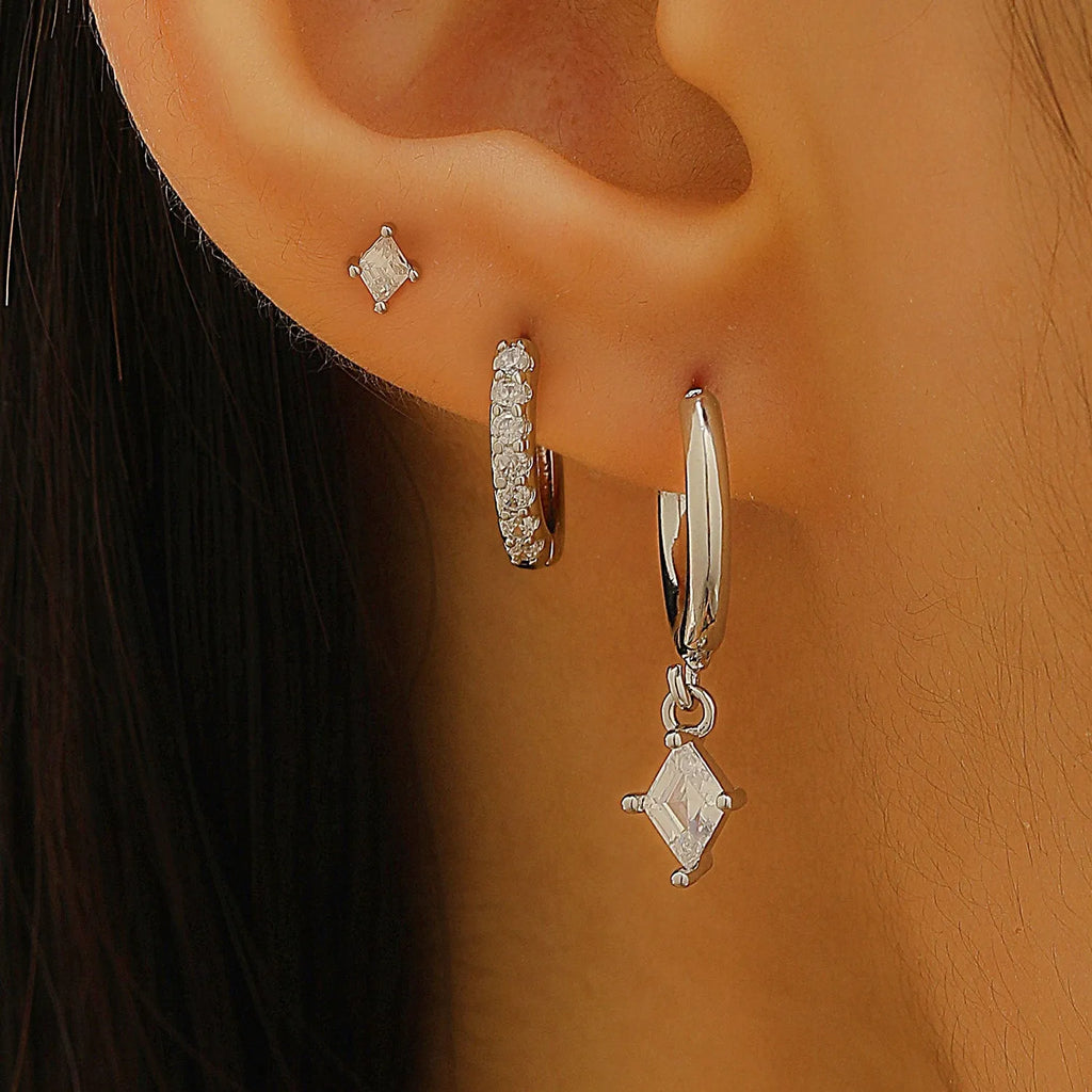 Gold and white geometric earring set with pendant, studs, and clasps featuring inlaid zircon.