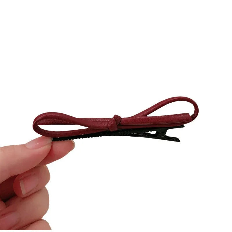 Wine red leather bow hair barrettes showing bow design and leather material