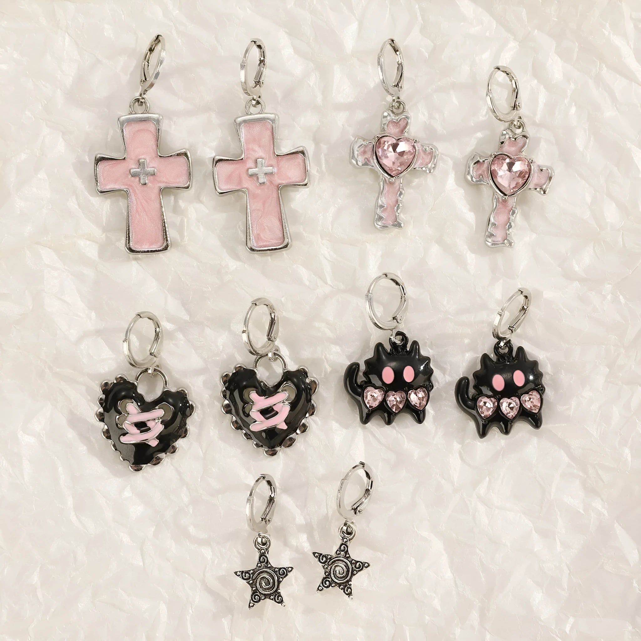 Women's alloy earrings showing cross, heart, and animal designs in white, black, and silver colour variations