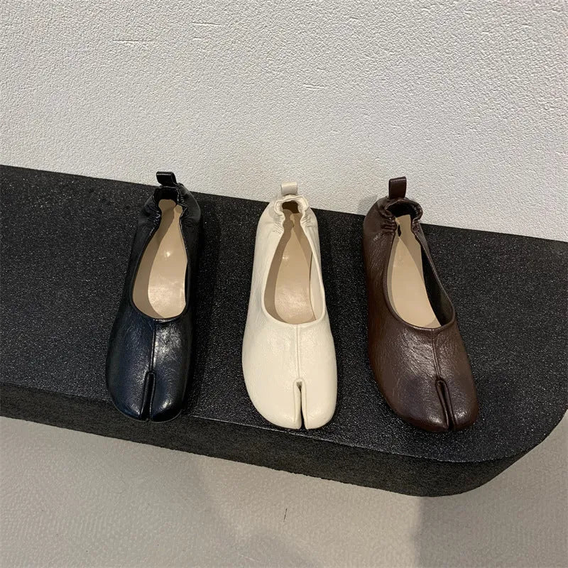 Women's black chunky heel pumps with a rounded toe and split toe horseshoe pea detail.