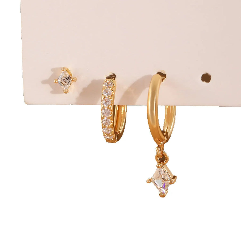 Gold and white geometric earring set with pendant, studs, and clasps featuring inlaid zircon.