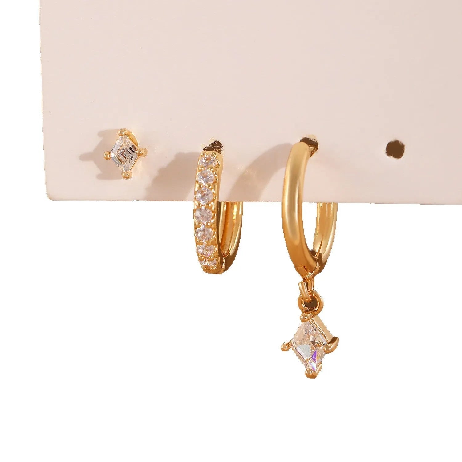 Gold and white geometric earring set with pendant, studs, and clasps featuring inlaid zircon.
