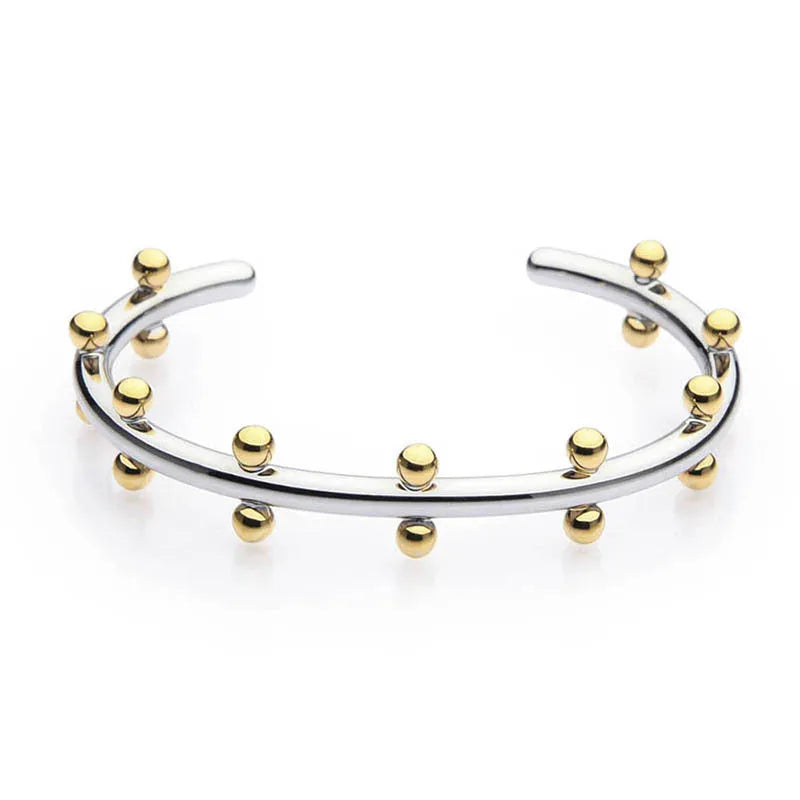 Stainless steel C-shaped bracelet with rivet-shaped bean beads in a steel-gold colour finish.