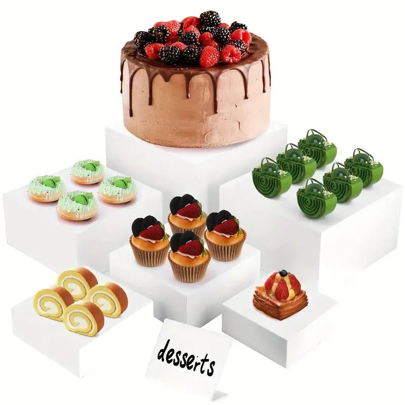 Six white plastic cube-shaped dessert display stands arranged in two rows for patisserie presentation