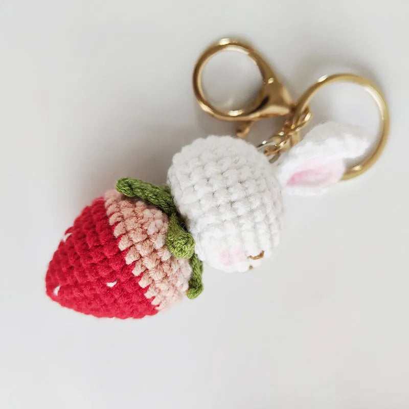 Hand-woven rabbit strawberry wire pendant with key attachment on white background