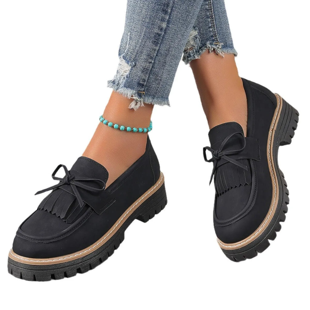 Women's black plus size slip-on loafers with tassel detail and a thick chunky heel.