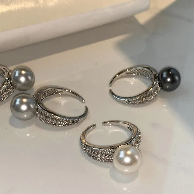Adjustable copper geometric ring with black pearl detail on open-ended design