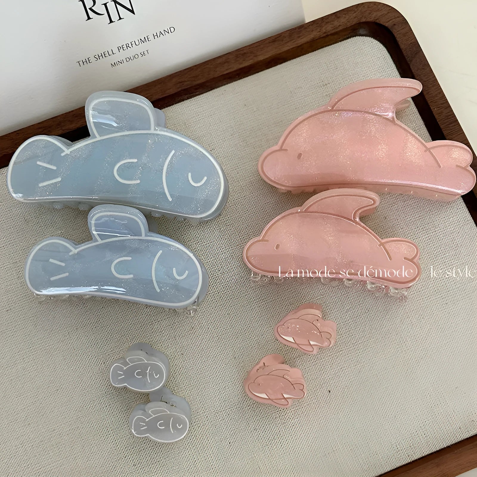 Women's dolphin grabber clip headdress in acetate material, available in blue and pink sizes, styled on hair
