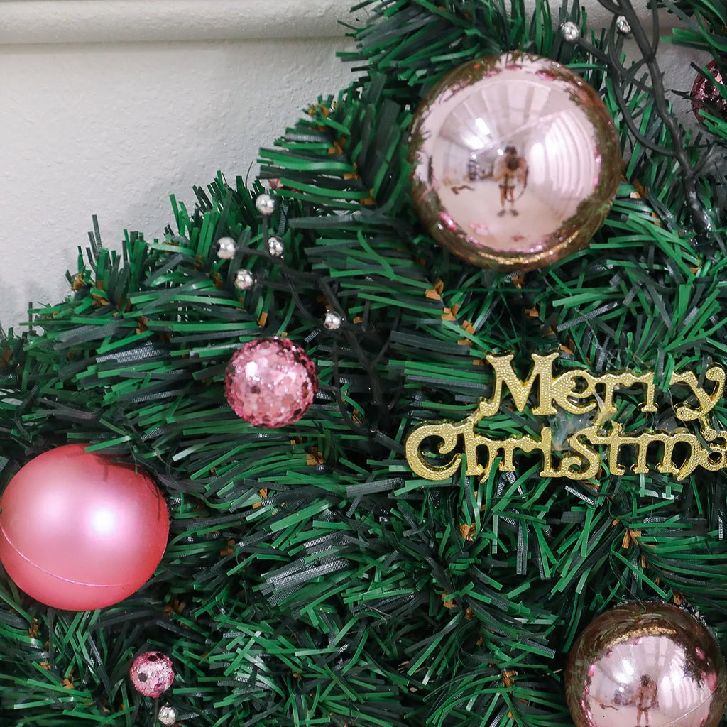A long, pink artificial rattan Christmas garland with small fruits and leaves, shown draped decoratively.