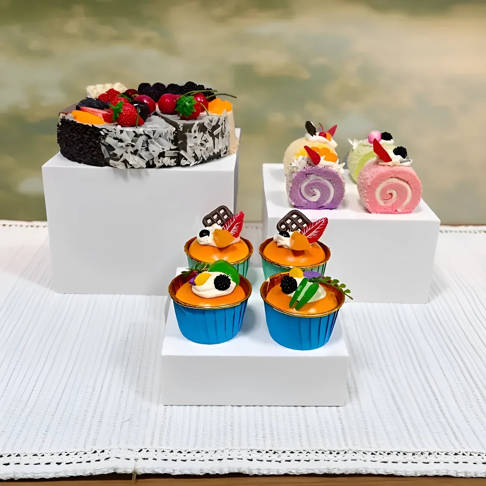 Six white plastic cube-shaped dessert display stands arranged in two rows for patisserie presentation