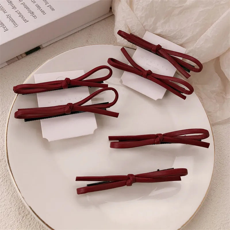 Wine red leather bow hair barrettes showing bow design and leather material