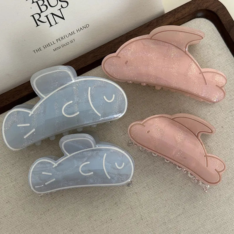 Women's dolphin grabber clip headdress in acetate material, available in blue and pink sizes, styled on hair