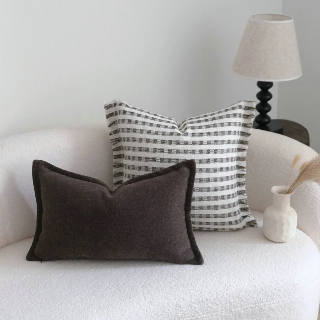 Coffee brown striped decorative cushion on a sofa in Chinese classical mid-century modern style.