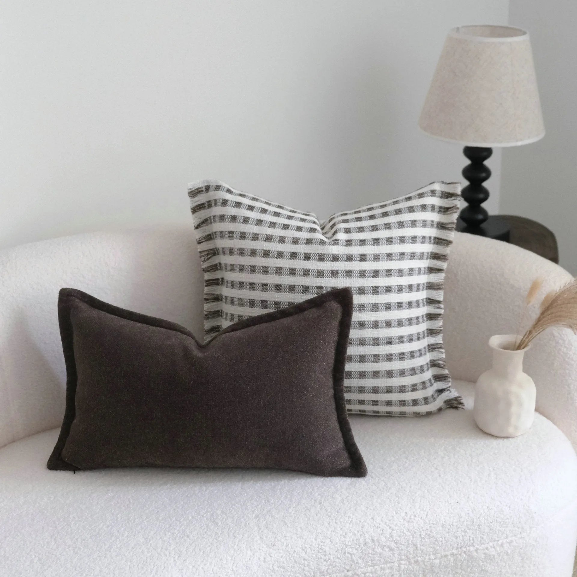 Coffee brown striped decorative cushion on a sofa in Chinese classical mid-century modern style.