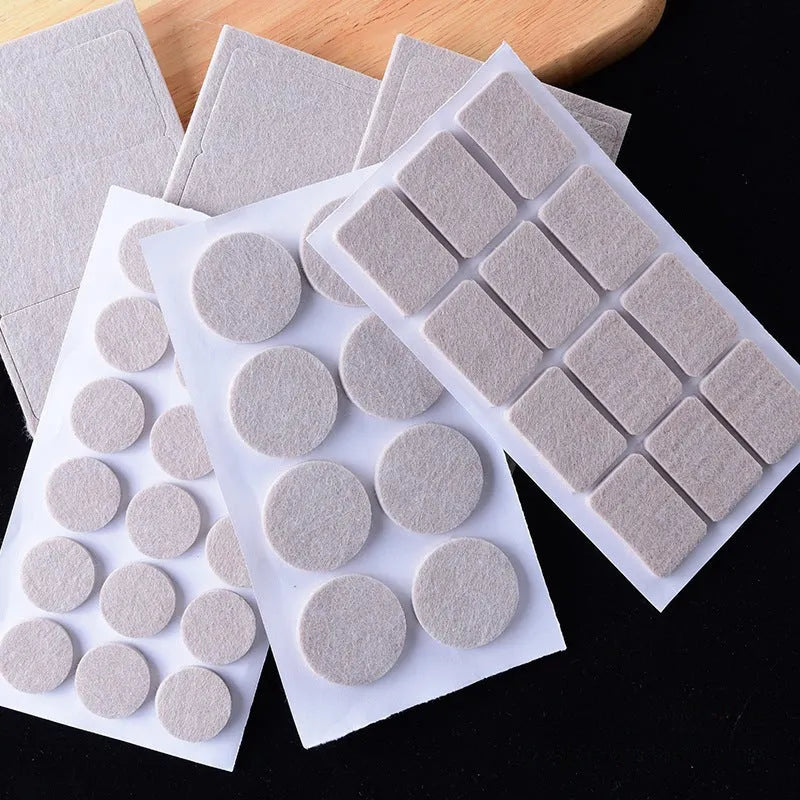 Beige plastic furniture leg protection pads in round and square shapes on wooden floor