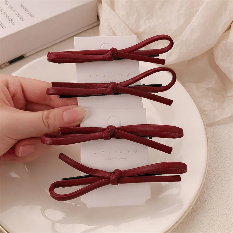 Wine red leather bow hair barrettes showing bow design and leather material