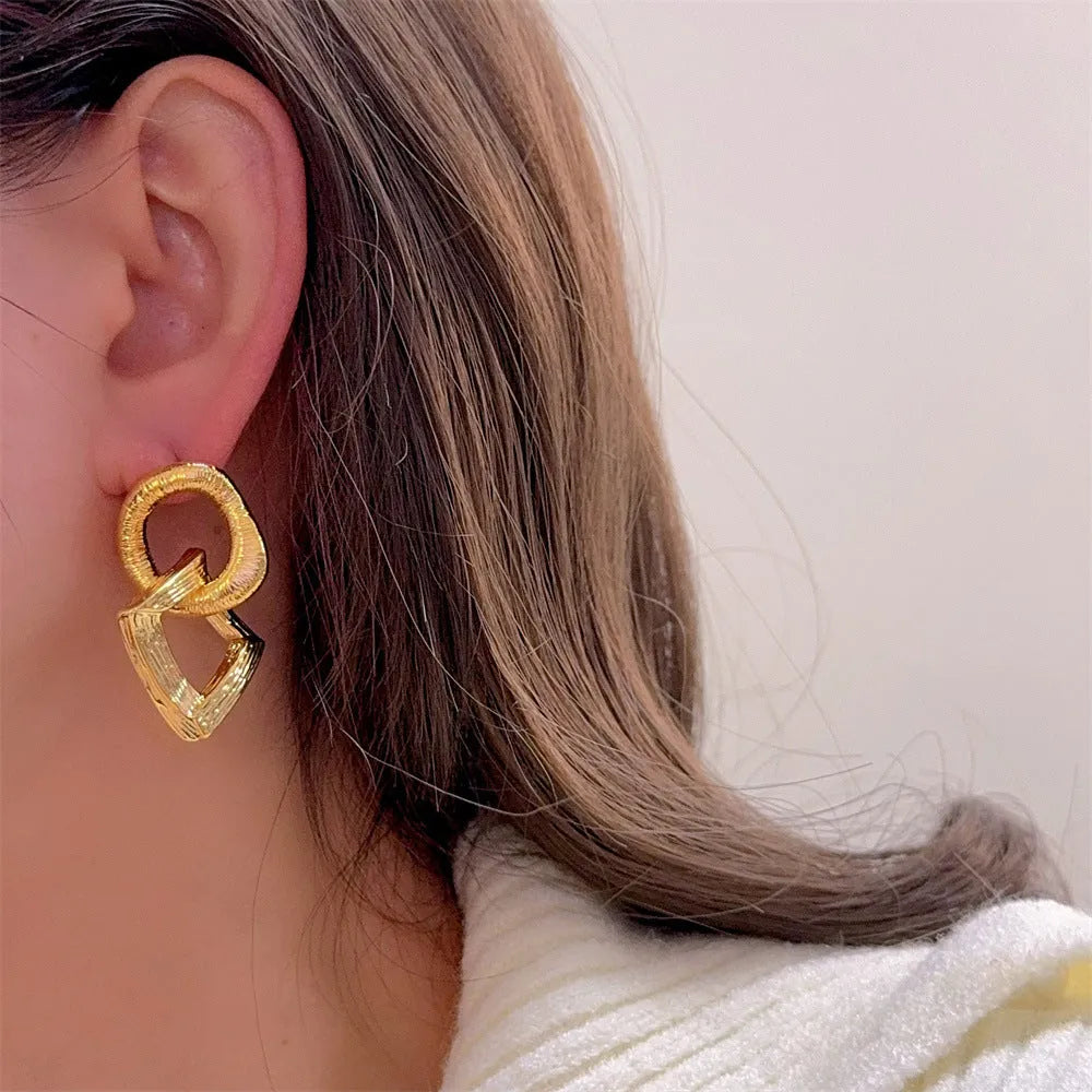 A pair of retro-style geometric circle pendant drop earrings with a 3.4cm length in a gold electroplated finish.