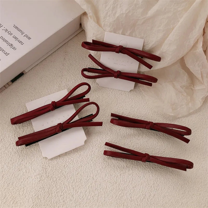 Wine red leather bow hair barrettes showing bow design and leather material