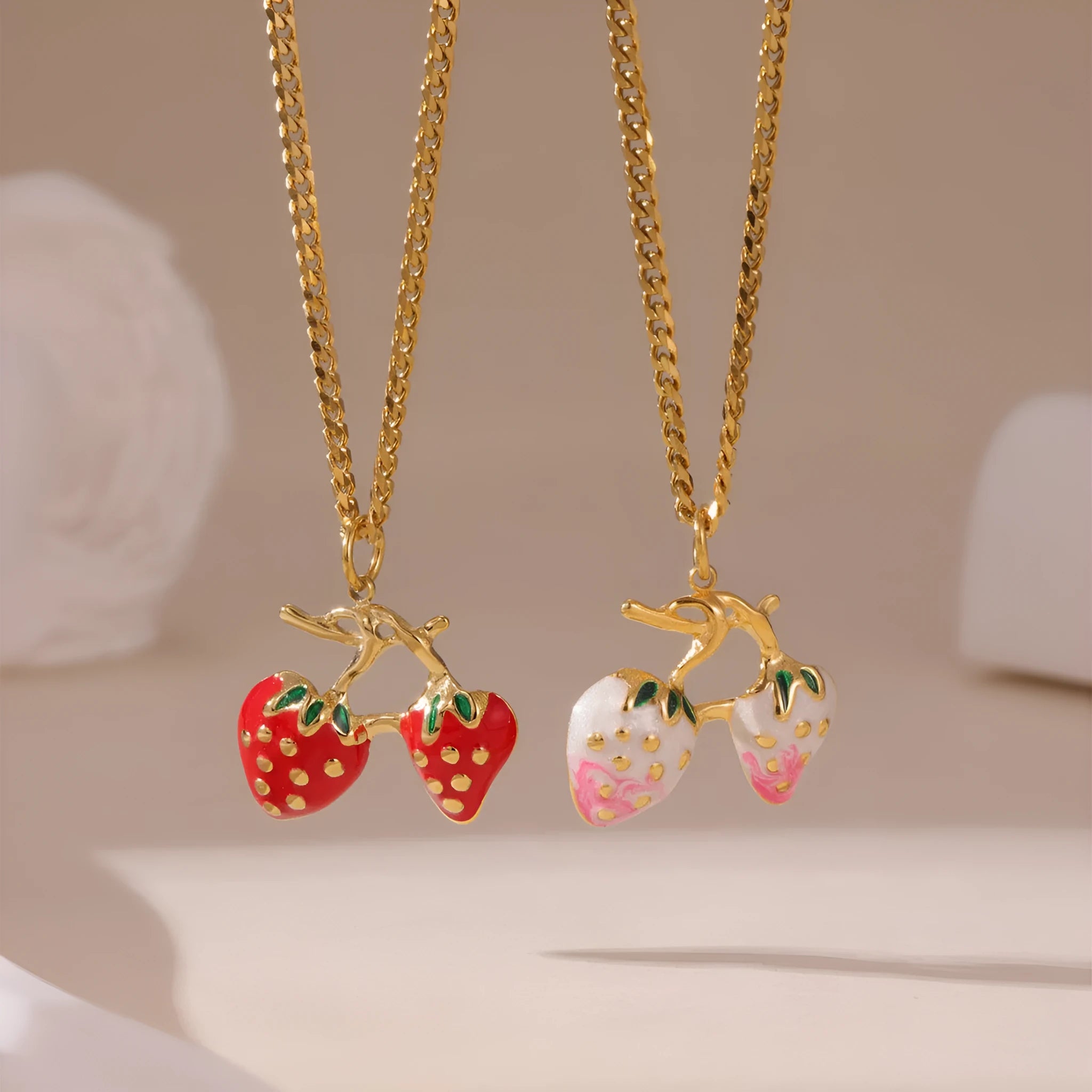 Stainless steel strawberry pendant necklace on a chain, shown in red and white gradient colour options.