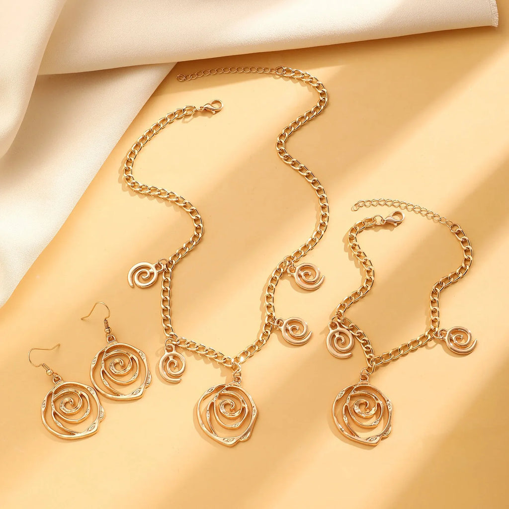 Gold and silver spiral donut pendant necklace, bracelet, and earrings set for women.
