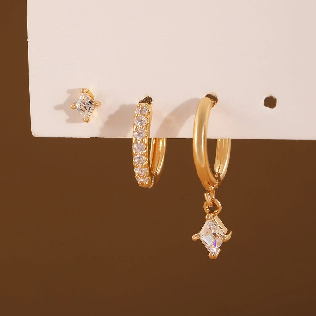 Gold and white geometric earring set with pendant, studs, and clasps featuring inlaid zircon.