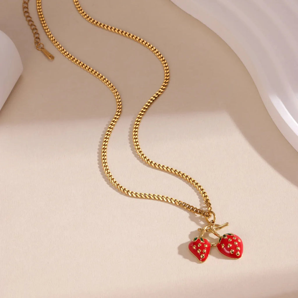 Stainless steel strawberry pendant necklace on a chain, shown in red and white gradient colour options.