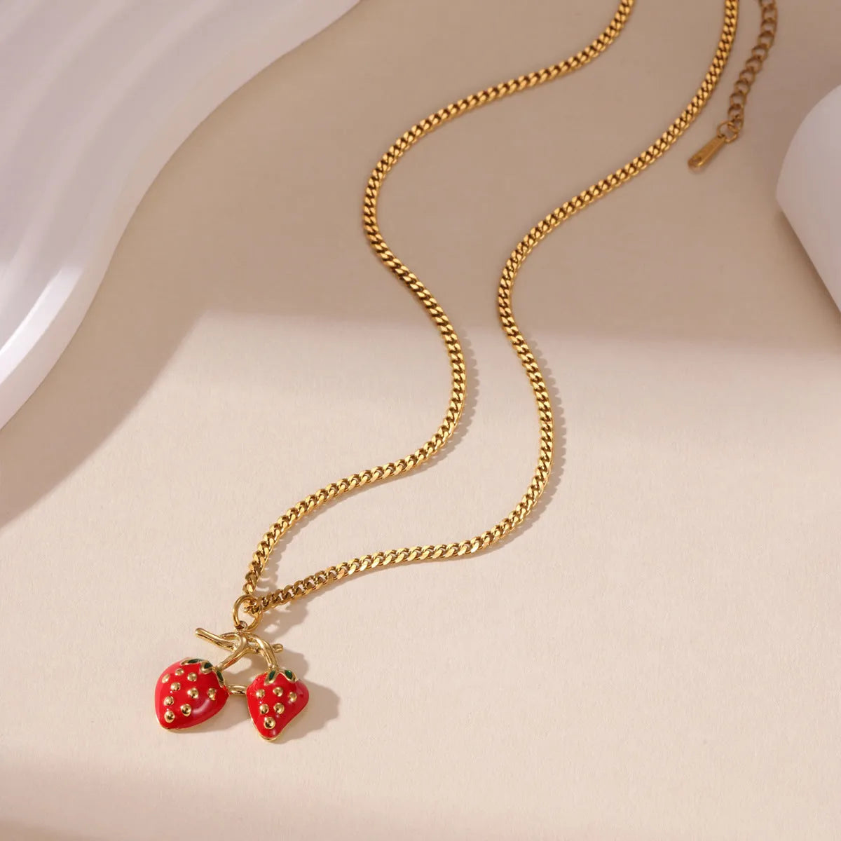 Stainless steel strawberry pendant necklace on a chain, shown in red and white gradient colour options.