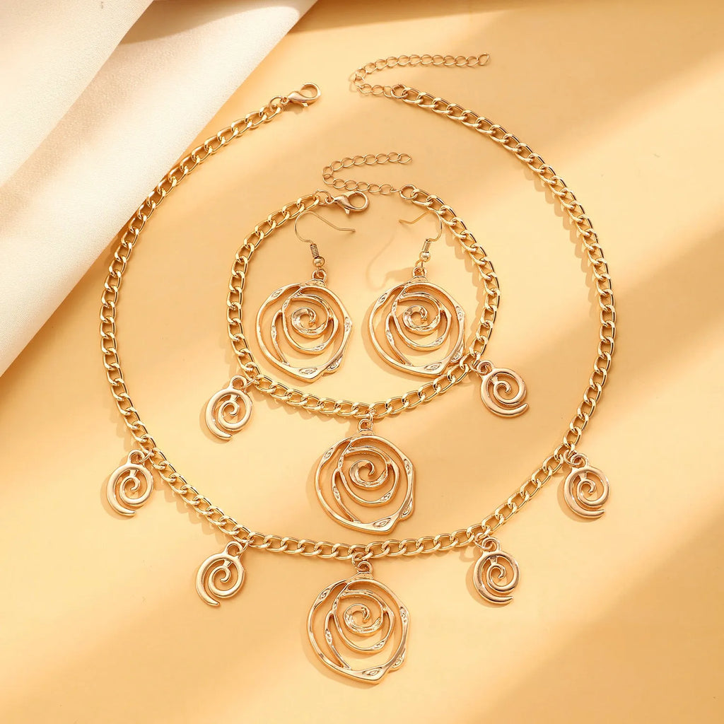 Gold and silver spiral donut pendant necklace, bracelet, and earrings set for women.